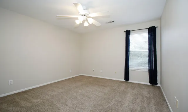 an empty room with chandelier fan