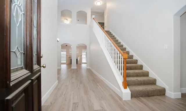 a view of a hallway with wooden floor and staircase