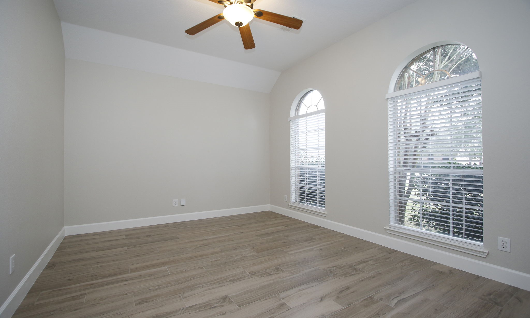 27131 Sunset Pines Drive Spring, TX 77373 - Photo 7 of 44 an empty room with wooden floor chandelier fan and windows