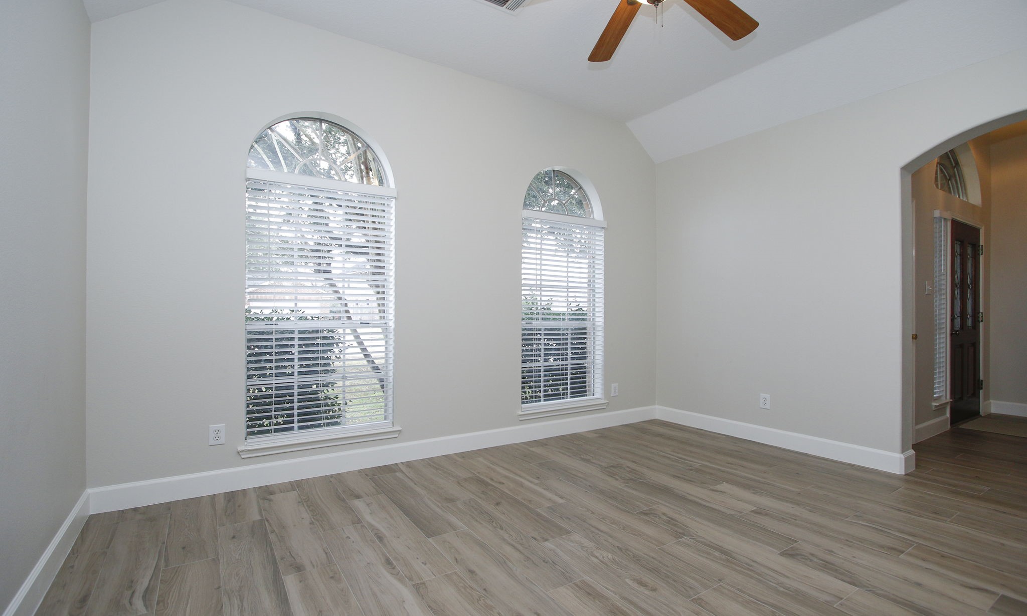 27131 Sunset Pines Drive Spring, TX 77373 - Photo 8 of 44 an empty room with wooden floor chandelier fan and windows