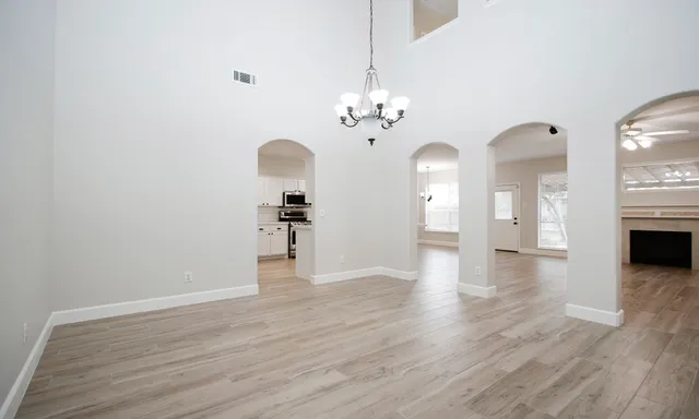 a view of a livingroom with a fireplace wooden floor and a chandelier