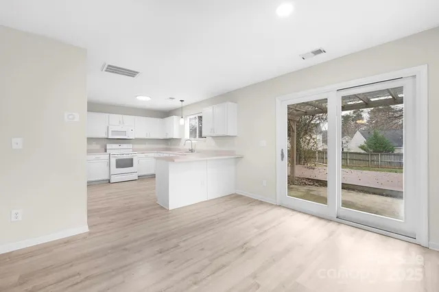 a view of kitchen with wooden floor and electronic appliances