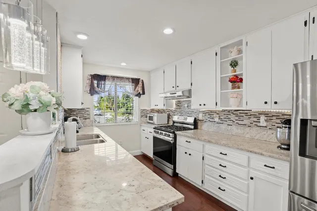 a bathroom with a granite countertop sink toilet mirror and shower