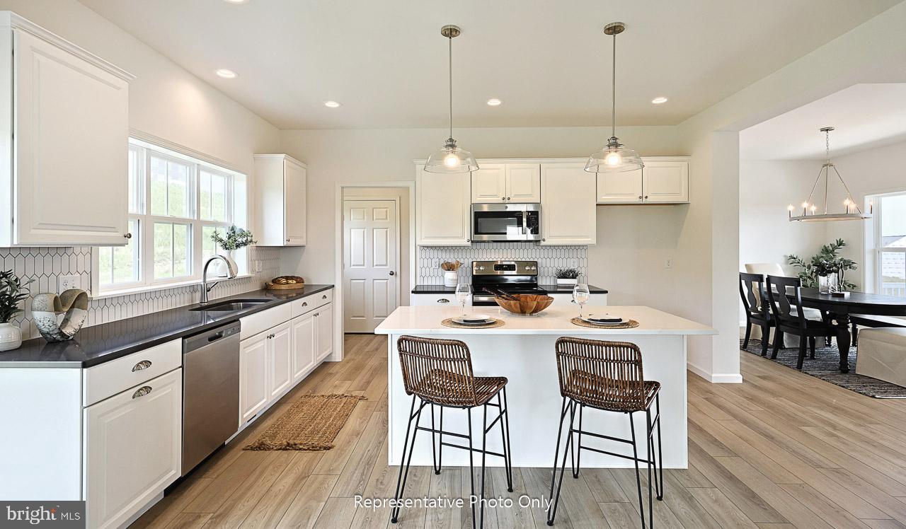 109 Copper Ridge Drive Newmanstown, PA 17073 - Photo 9 of 27 a kitchen with kitchen island granite countertop a sink a center island and cabinets