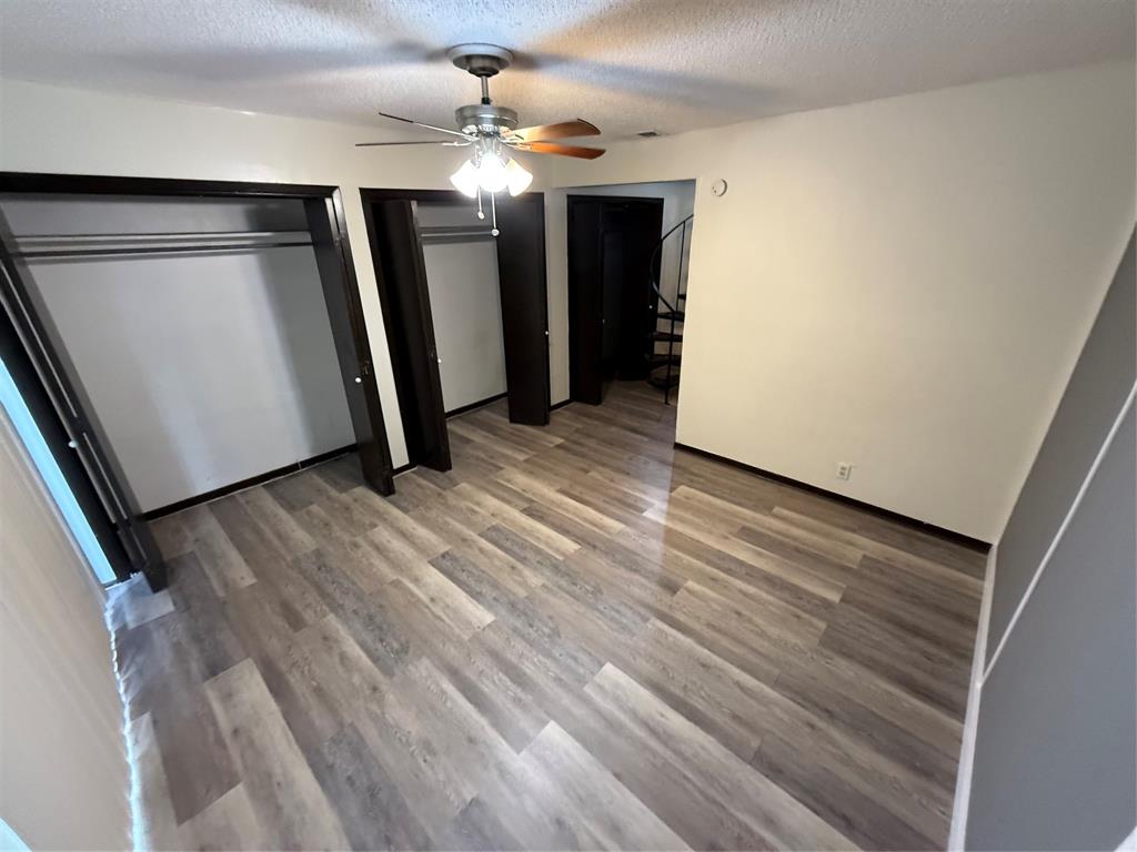 2408 Longview Street, Unit 104 Austin, TX 78705 - Photo 3 of 5 a view of a livingroom with wooden floor and staircase