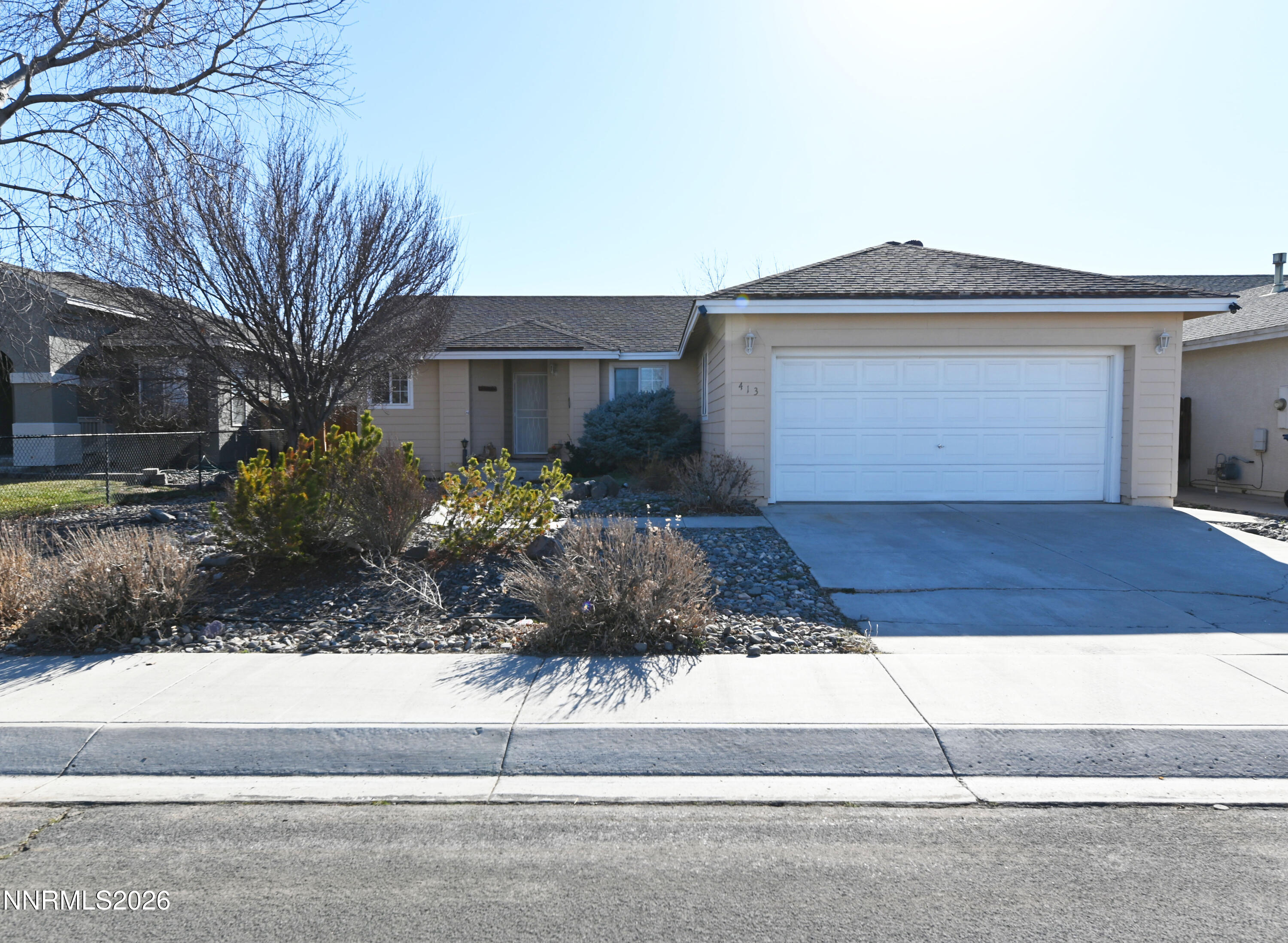 413 Sunshine Lane Fernley, NV 89408 - Photo 1 of 10 a front view of a house with a yard and garage