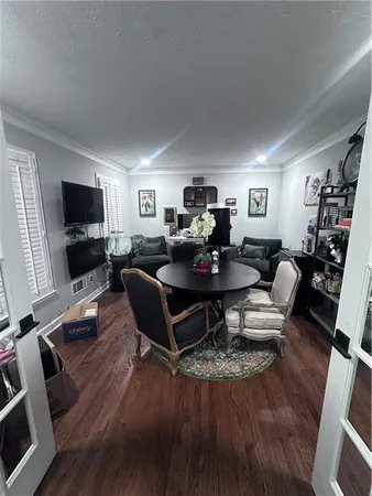 a living room with furniture flat screen tv and wooden floor