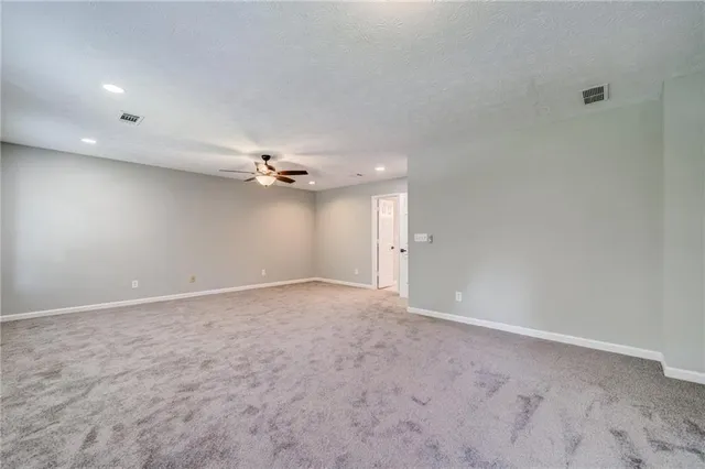 an empty room with a ceiling fan and a window