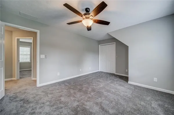 an empty room with closet and fan