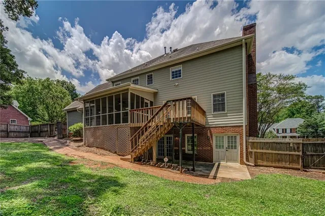 a view of a house with a yard and a large tree