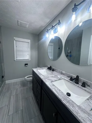 a bathroom with a granite countertop double vanity sink and a mirror