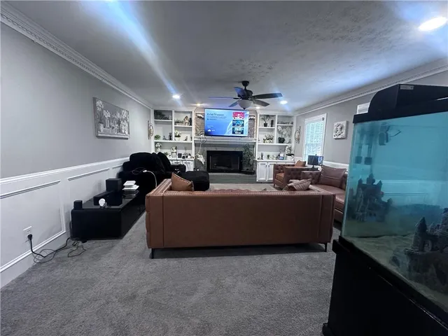 a living room with furniture a fireplace and a flat screen tv