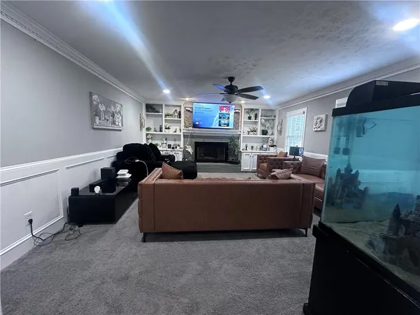 a living room with furniture a fireplace and a flat screen tv