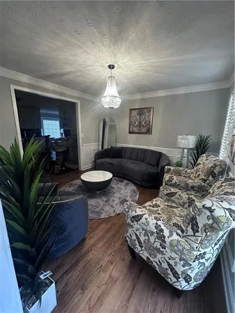 a living room with furniture a chandelier and a fireplace