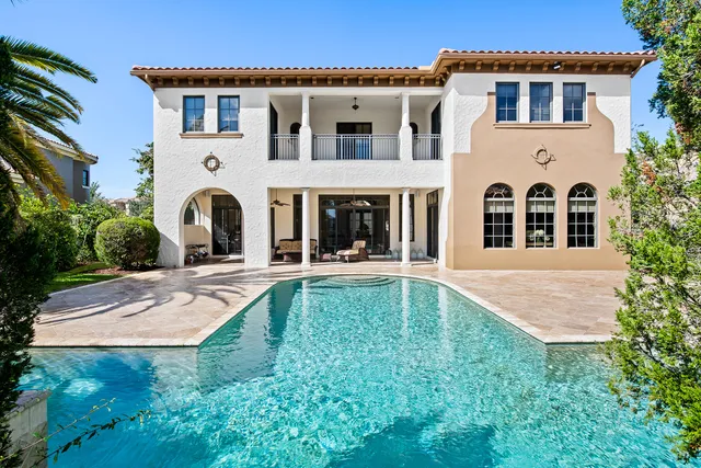 a front view of a house with a yard and potted plants