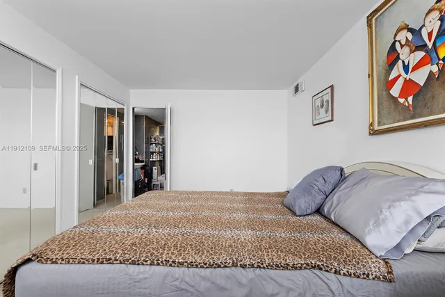 a bedroom with a large bed and a book shelf