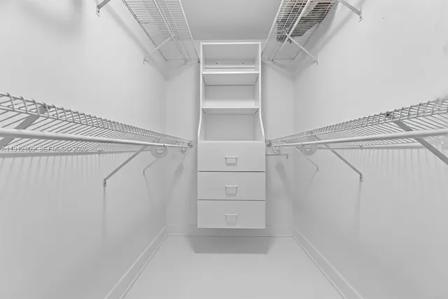 a view of walk in closet with empty racks