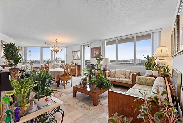 a living room with furniture potted plant and a large window