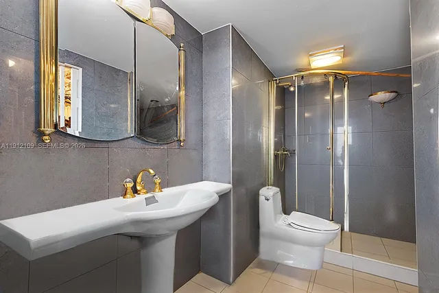 a bathroom with a sink a toilet a mirror and shower