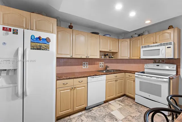 a kitchen with stainless steel appliances granite countertop a stove a sink dishwasher and a refrigerator