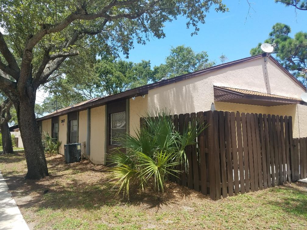 2007 Oleander Boulevard, Unit B Fort Pierce, FL 34950 - Photo 1 of 17 a backyard of a house with potted plants and large tree