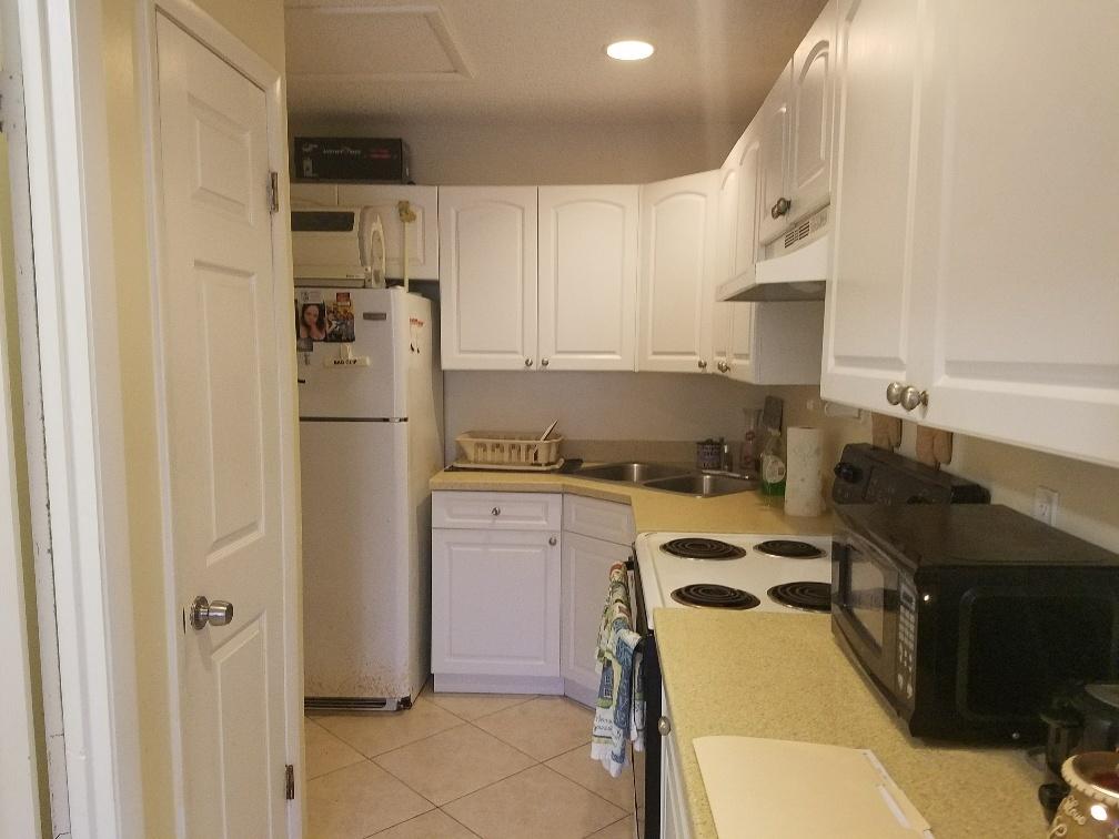 2007 Oleander Boulevard, Unit B Fort Pierce, FL 34950 - Photo 12 of 17 a kitchen with a refrigerator and a stove