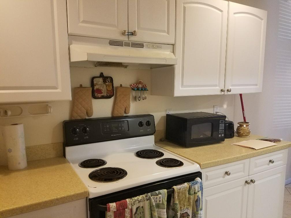 2007 Oleander Boulevard, Unit B Fort Pierce, FL 34950 - Photo 13 of 17 a kitchen with a stove and a white cabinets