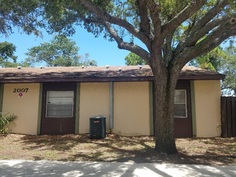 2007 Oleander Boulevard, Unit B Fort Pierce, FL 34950 - Photo 3 of 17 a view of a house with a tree and wooden fence