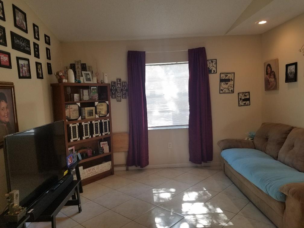 2007 Oleander Boulevard, Unit B Fort Pierce, FL 34950 - Photo 7 of 17 a living room with furniture a bookshelf and a window