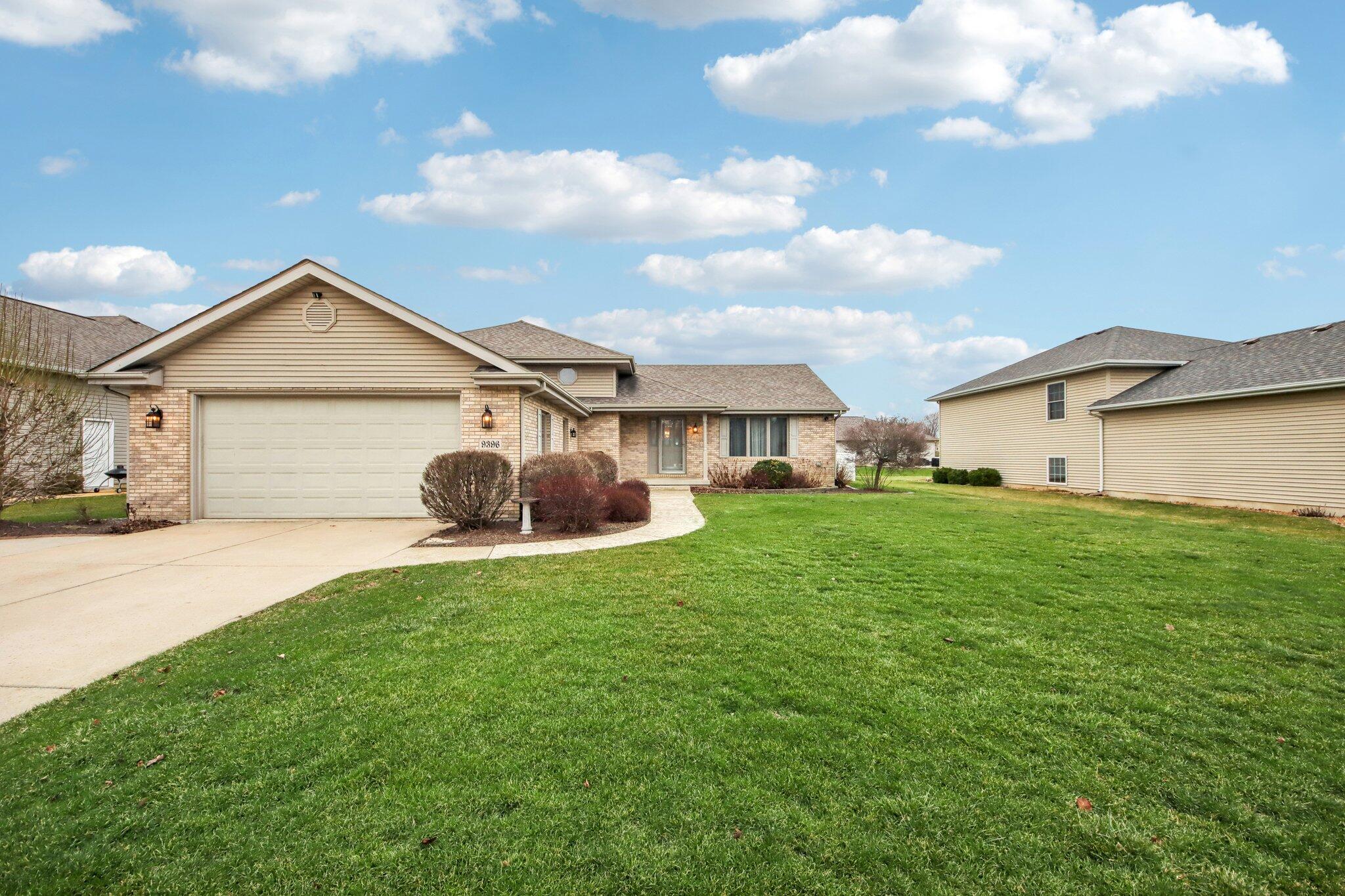 a front view of a house with a garden and yard