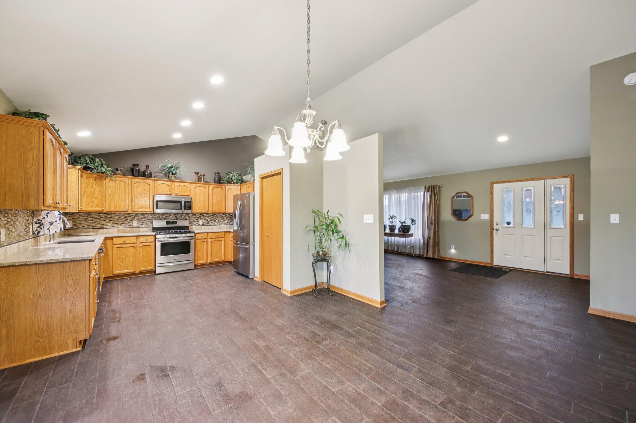 9396 Calumet Street Dyer, IN 46311 - Photo 12 of 43 a view of a kitchen with a sink dishwasher stove and kitchen island with wooden floor