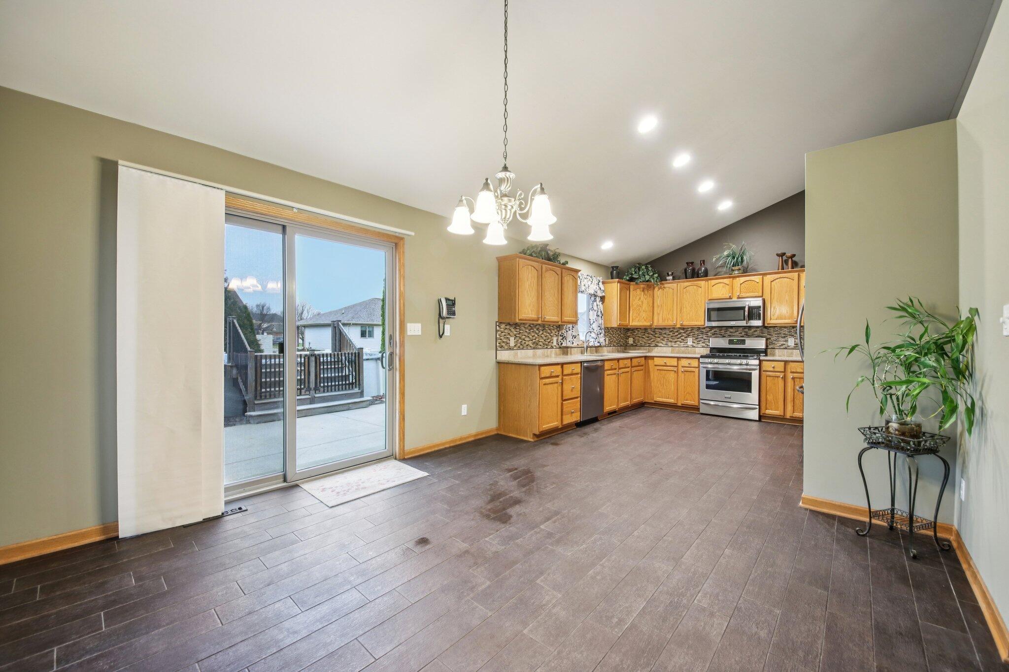 9396 Calumet Street Dyer, IN 46311 - Photo 10 of 43 a living room with furniture and a kitchen with chandelier