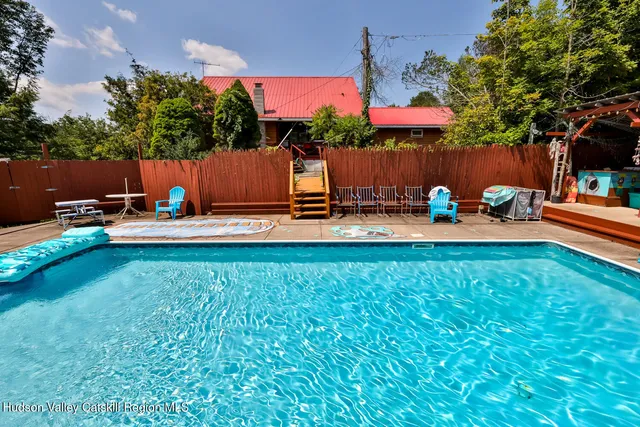 a living room with furniture a flat screen tv and a floor to ceiling window