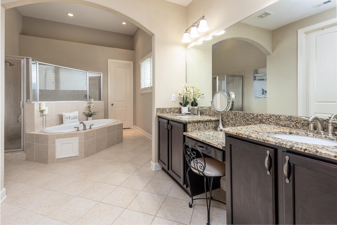 771 Six Oaks Lane Collierville, TN 38017 - Photo 12 of 25 a bathroom with a granite countertop double vanity sink a mirror and a bathtub