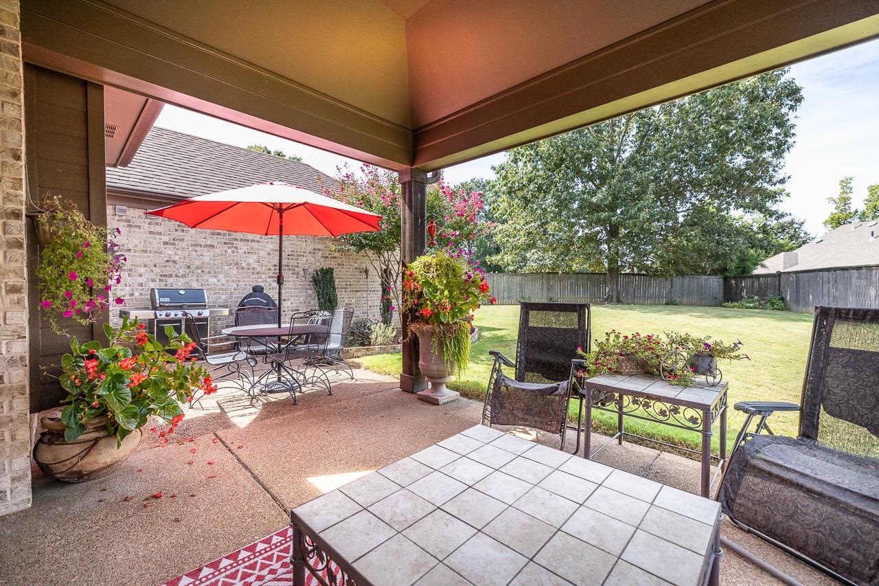 771 Six Oaks Lane Collierville, TN 38017 - Photo 23 of 25 a view of a patio with a table and chairs under an umbrella