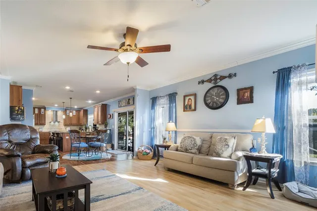 a living room with furniture kitchen view and a window