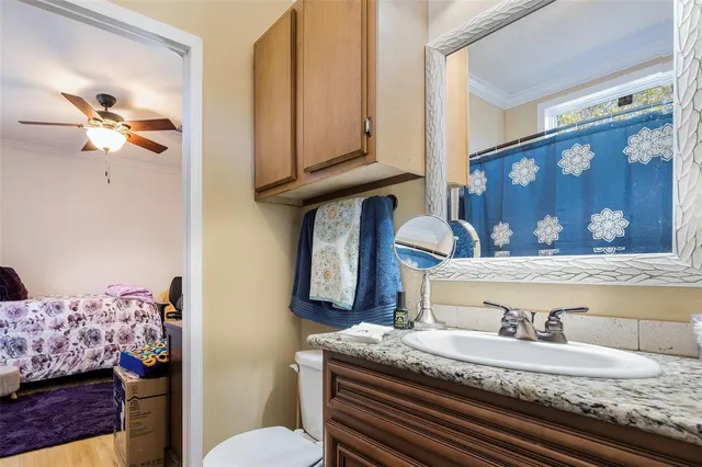 a bathroom with a granite countertop sink a toilet and a mirror