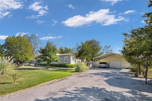 a front view of a house with a yard and trees
