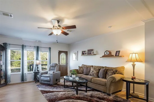 a living room with furniture ceiling fan and a window