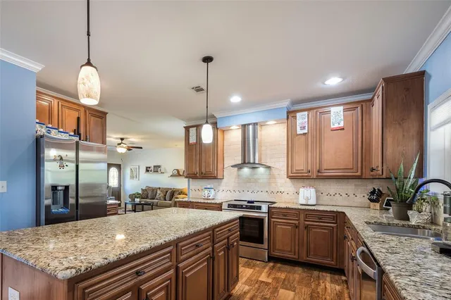 a kitchen with granite countertop kitchen island stainless steel appliances a sink stove and kitchen island