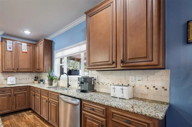 a kitchen with granite countertop cabinets sink and window