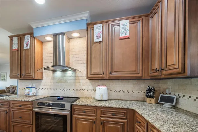 a kitchen with stainless steel appliances granite countertop a stove a sink and a microwave
