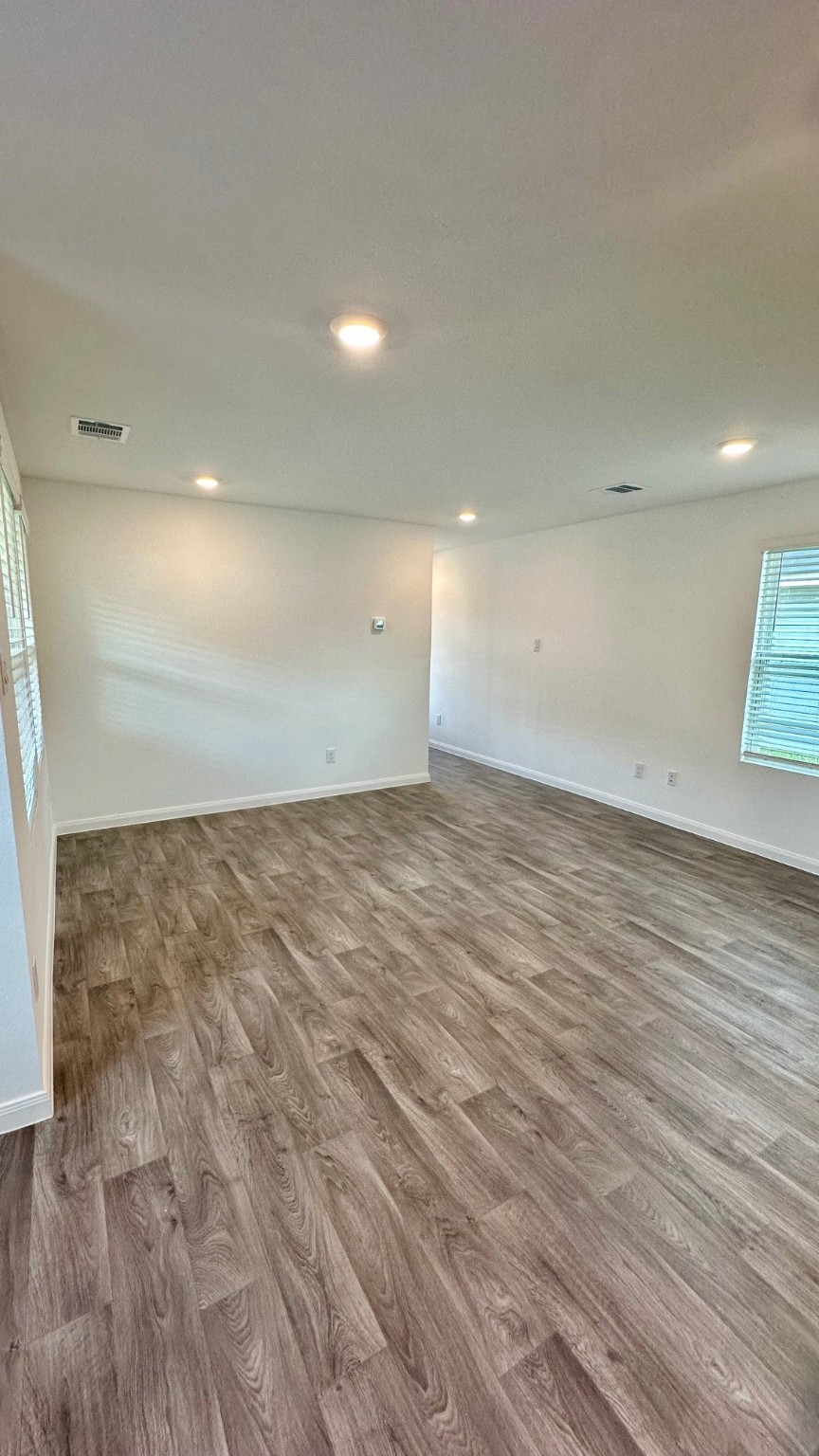 11926 Midas Lane Willis, TX 77378 - Photo 13 of 28 an empty room with wooden floor and windows