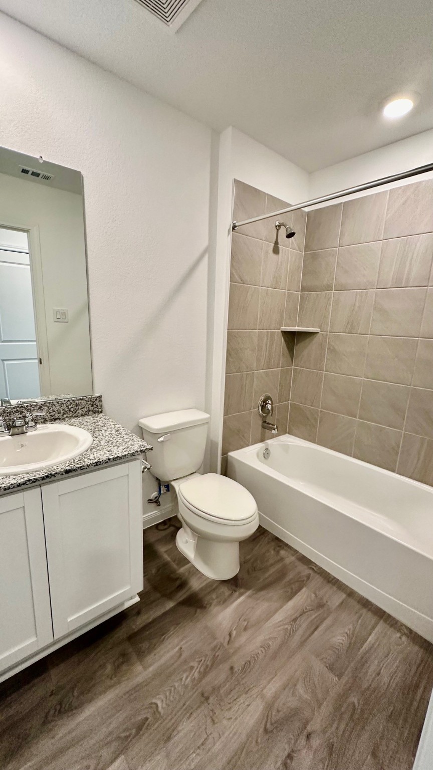 11926 Midas Lane Willis, TX 77378 - Photo 22 of 28 a bathroom with a granite countertop sink toilet a mirror and bathtub