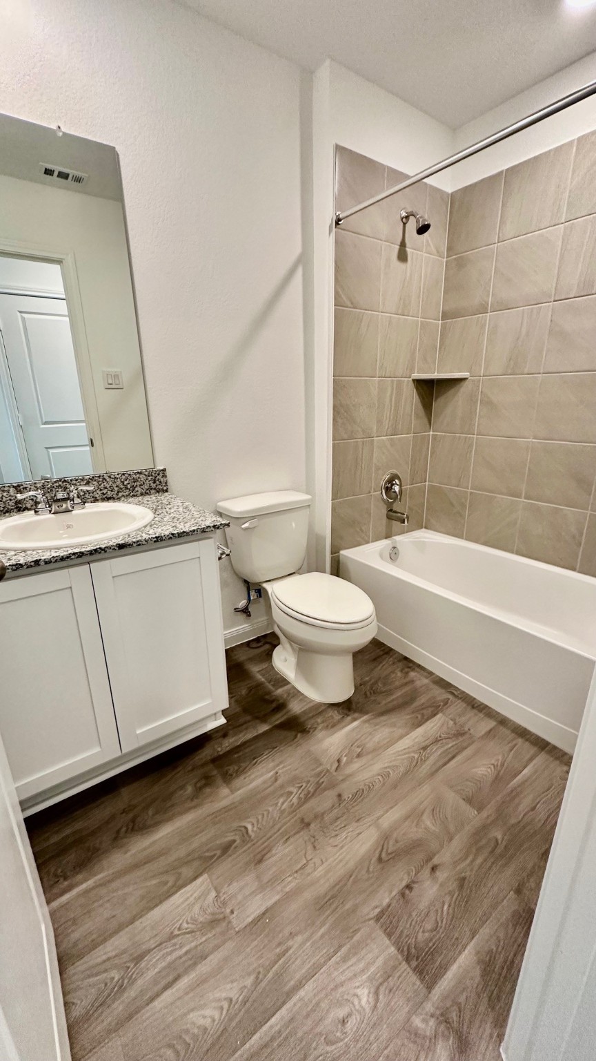 11926 Midas Lane Willis, TX 77378 - Photo 28 of 28 a bathroom with a sink toilet a mirror and bathtub