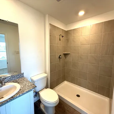 a bathroom with a granite countertop toilet a sink and bathtub