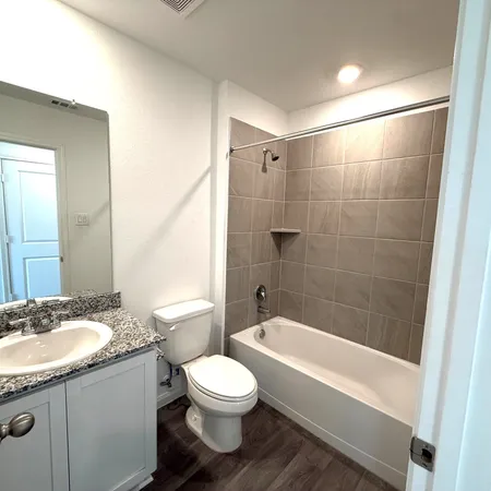 a view of kitchen with stainless steel appliances granite countertop a sink a stove and a refrigerator