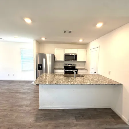 a view of a kitchen with a stove and refrigerator