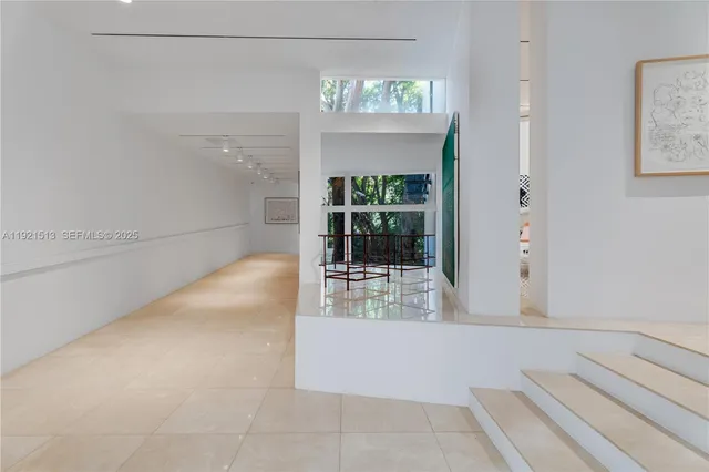 a kitchen that has a lot of white cabinets and stainless steel appliances