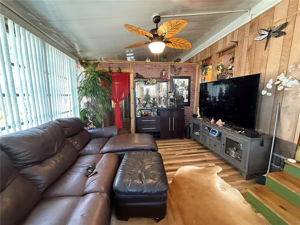 9408 Cougar Drive Weeki Wachee, FL 34613 - Photo 4 of 27 a living room with furniture and a flat screen tv